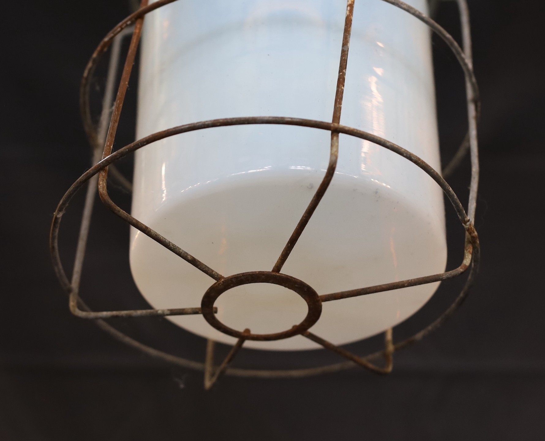 A pair of Czechoslovakian painted alloy industrial ceiling lights with caged Vaseline glass shades, height 74cm. width 21cm